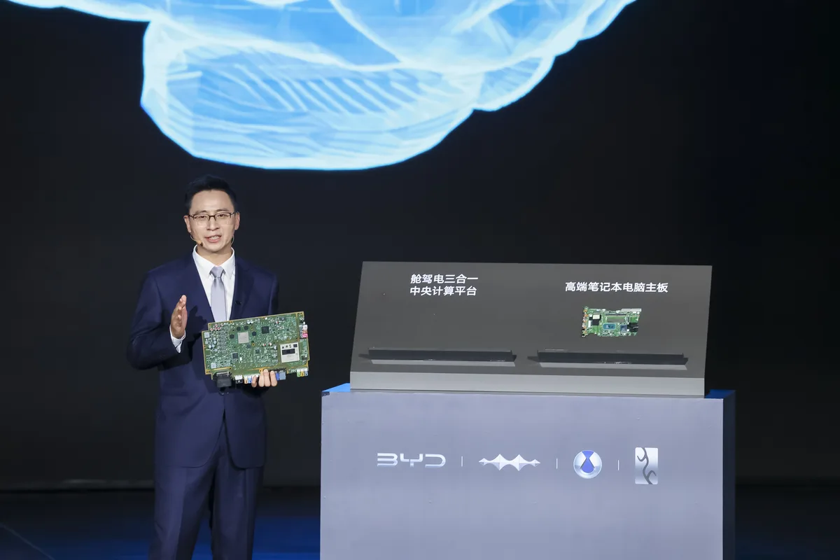 BYD presenter holding a driving system board beside the God’s Eye technology display
