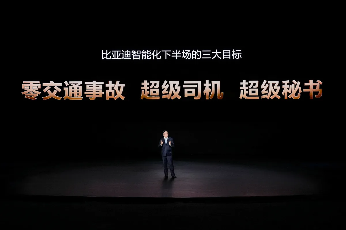 BYD presenter standing beneath the intelligent driving goals slide at the 2026 strategy event