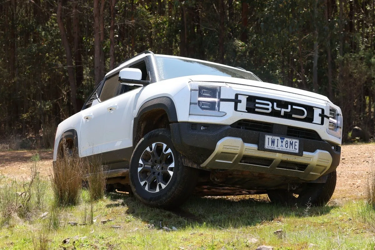 White BYD Shark 6 ute viewed from the front on a dirt track.