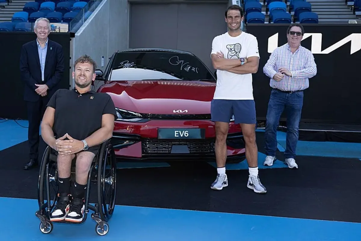 Damien Meredith standing with Dylan Alcott, Rafael Nadal, and a red Kia EV6 at the Australian Open.
