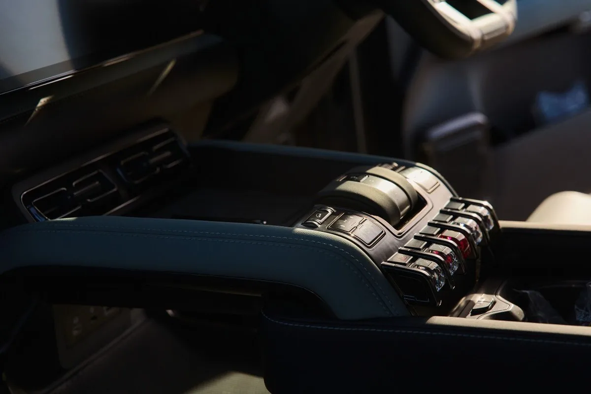 Denza B8 centre console showing gloss-black drive controls, switches and stitched trim.