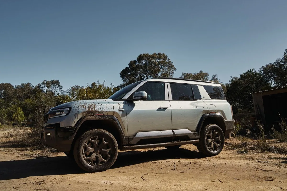 Denza B8 side profile in bushland with mud across the doors, wheel arches and tyres.