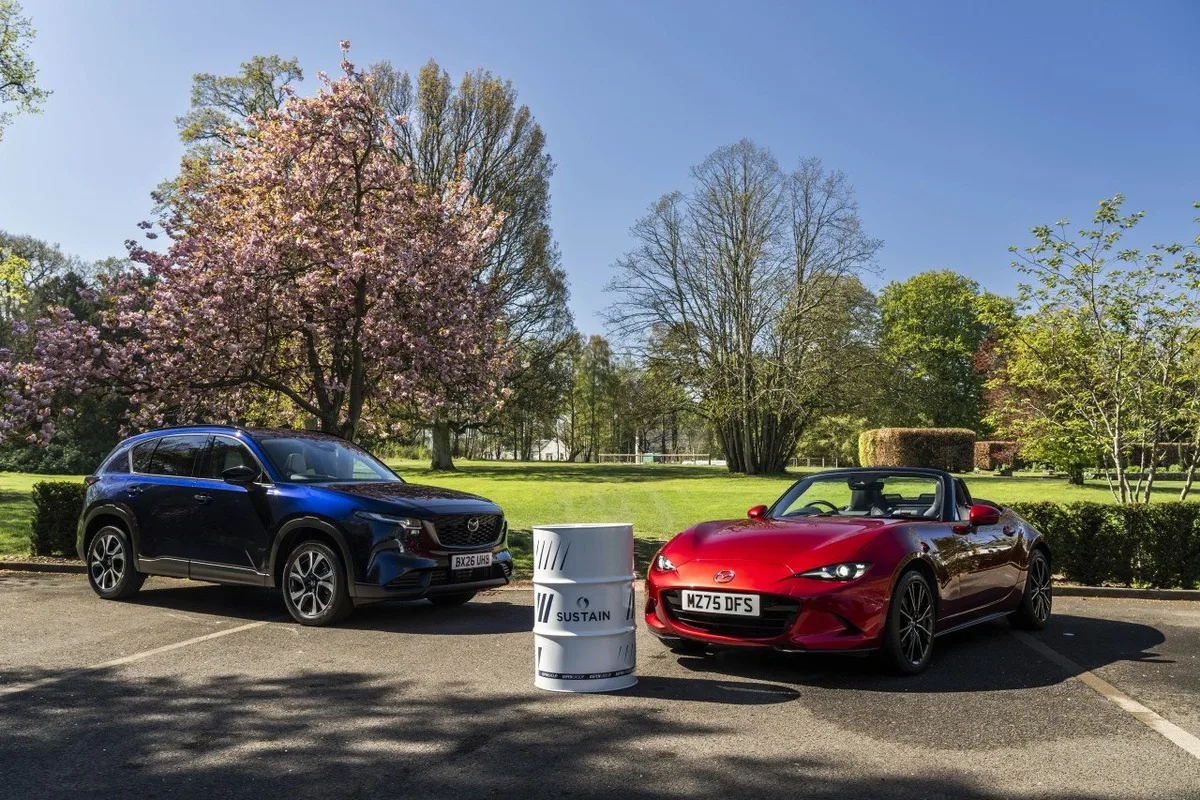 Dark blue Mazda CX-5 and red Mazda MX-5 displayed beside a SUSTAIN biofuel drum