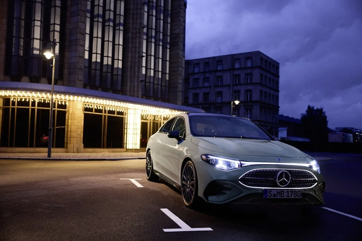 All-new Mercedes-Benz CLA in pale paint on a city street at dusk.