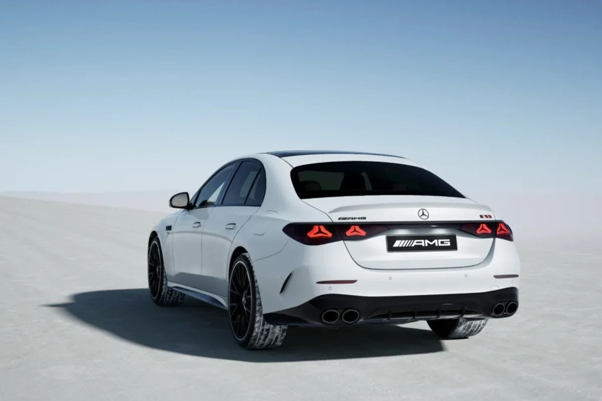White Mercedes-Benz E 300 AMG Night Edition rear three-quarter view with AMG badging and quad exhaust outlets.