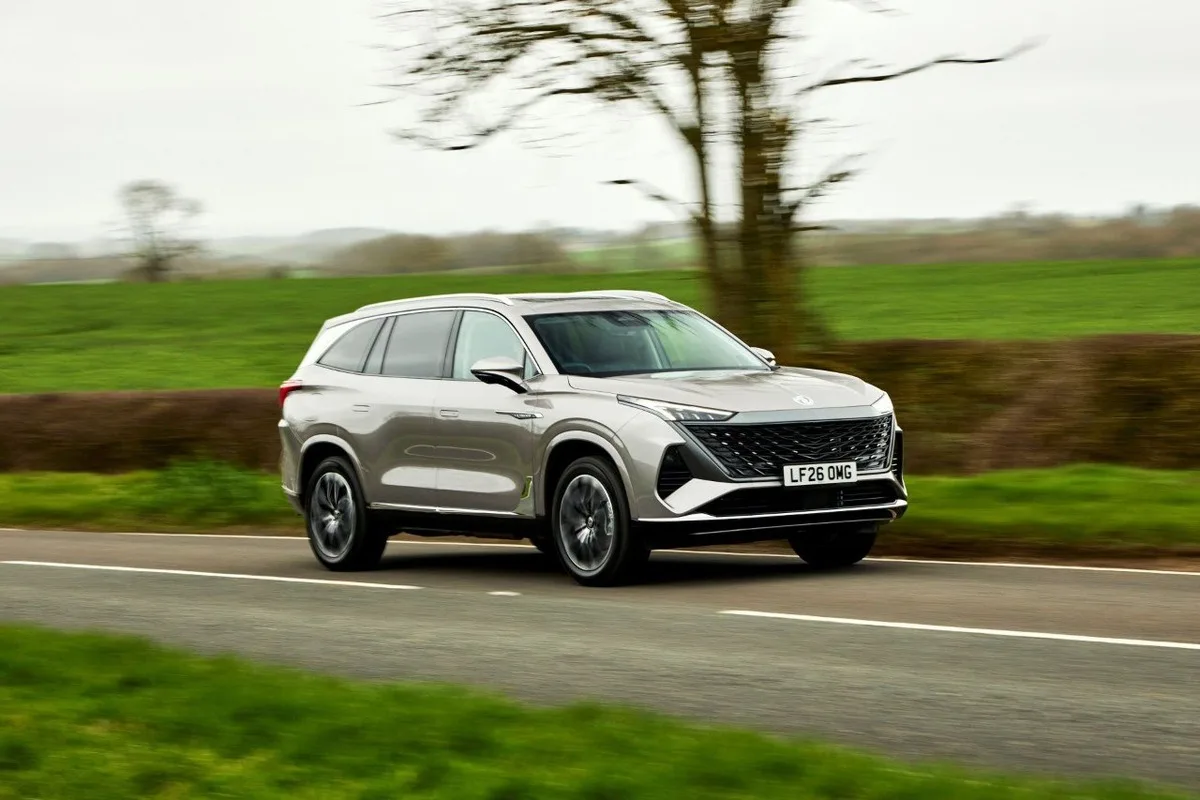 Silver MG SUV driving on a country road