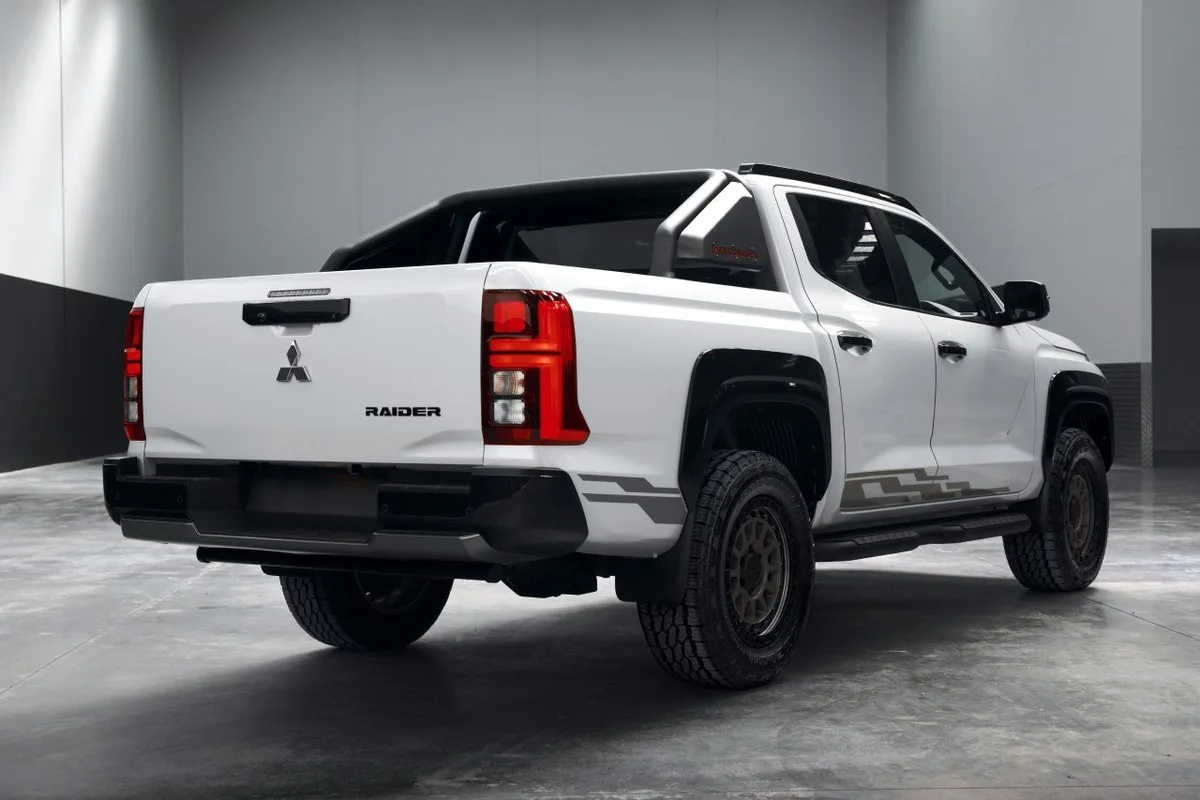 White Mitsubishi Triton Raider photographed from the rear in a studio with Raider tailgate badge.