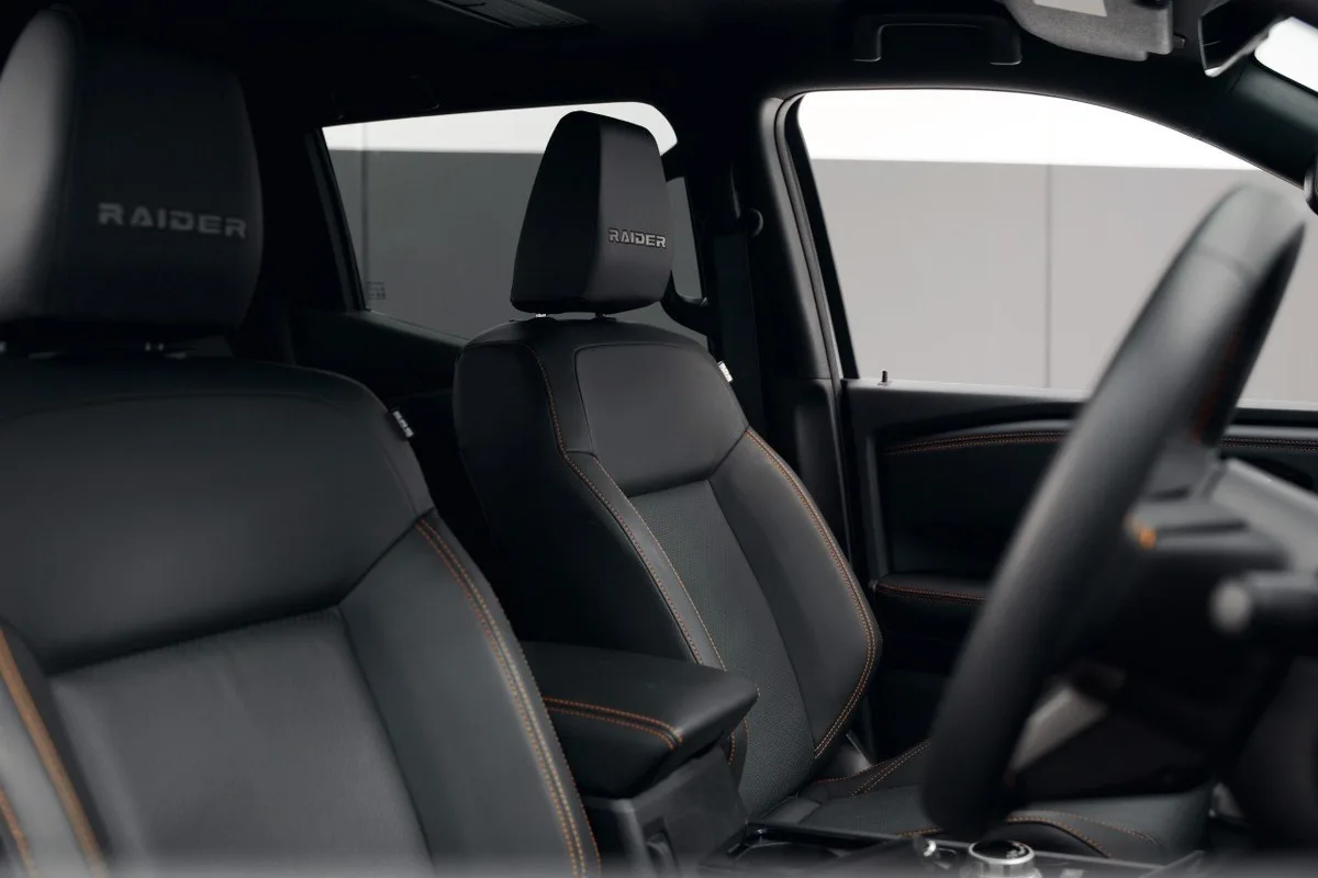 Mitsubishi Triton Raider cabin with black leather seats and Raider headrest embroidery.