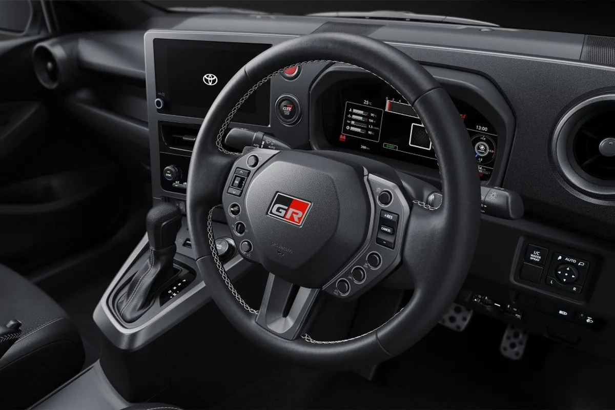 Toyota GR Yaris cockpit showing the smaller GR steering wheel, digital instruments and automatic gear selector.