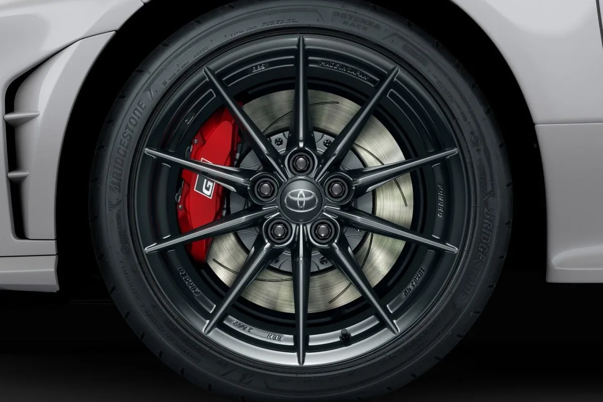 Toyota GR Yaris wheel detail showing Bridgestone Potenza Race tyre, black alloy wheel and red GR brake caliper.