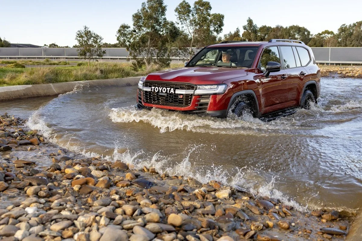 Toyota LandCruiser 300 GR Sport performance hybrid driving through a water crossing