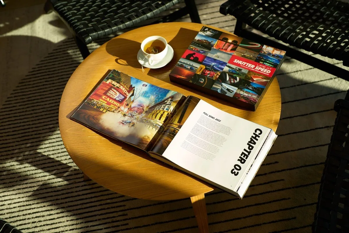 Automotive photography books including Shutter Speed Life at Speed on a coffee table.