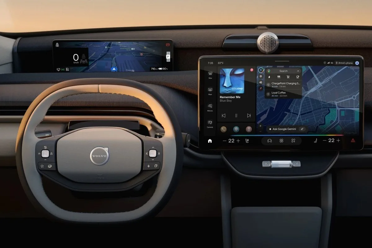 Volvo electric SUV cabin showing steering wheel, driver display and central touchscreen.