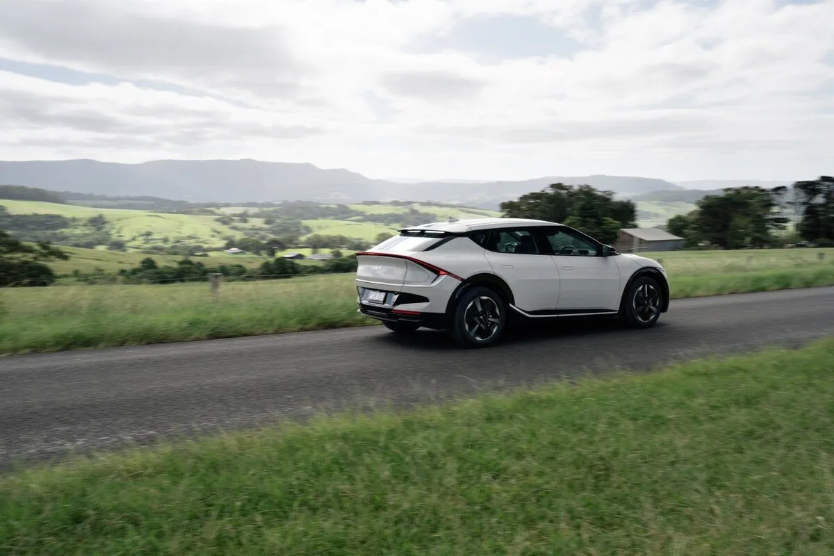 2026 Kia EV6 GT driving on a rural road in side profile