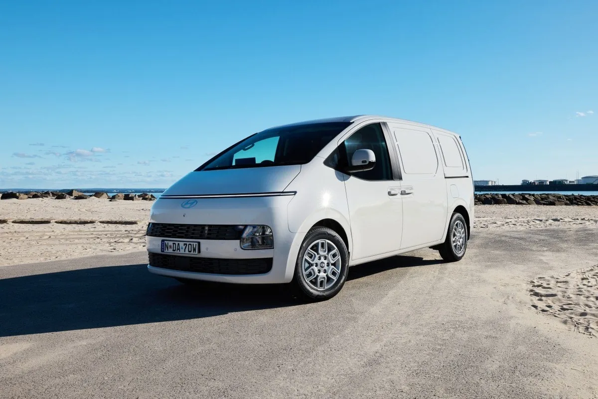 White 2027 Hyundai Staria Load front three-quarter view parked near the beach
