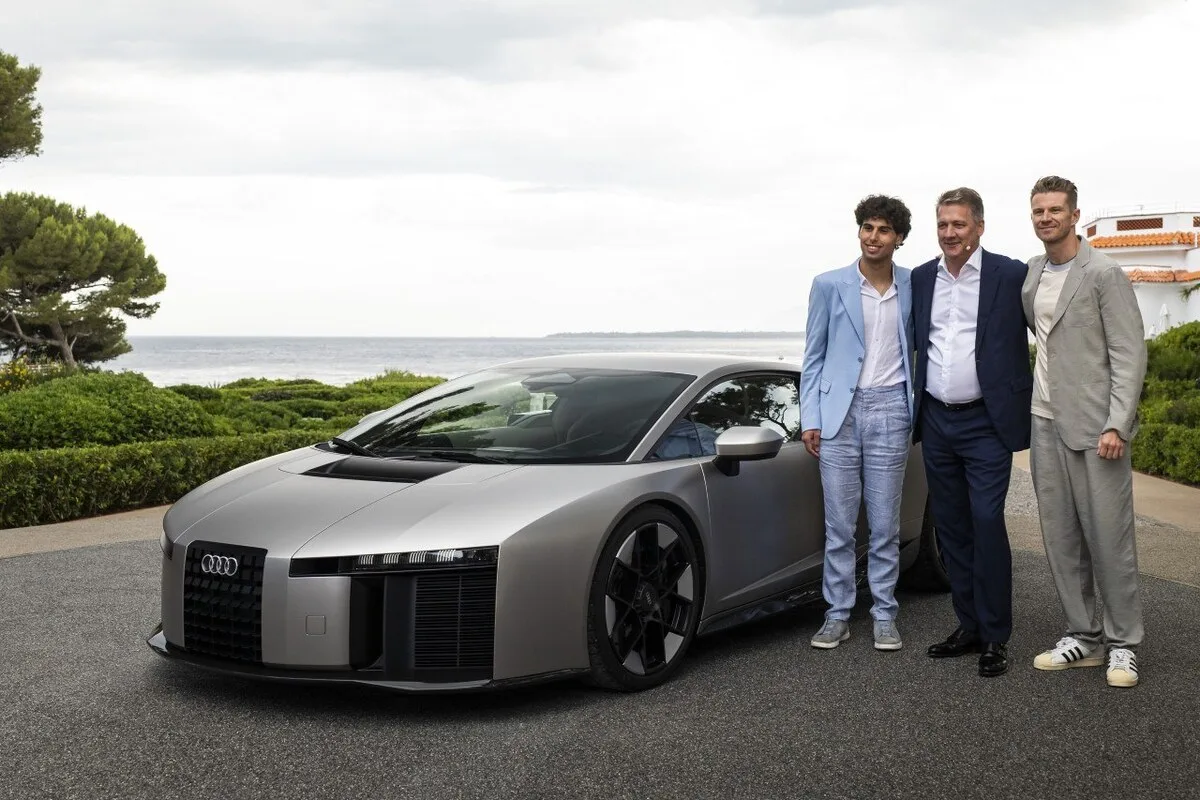Gabriel Bortoleto, an Audi executive, and Nico Hulkenberg standing beside the Audi Nuvolari