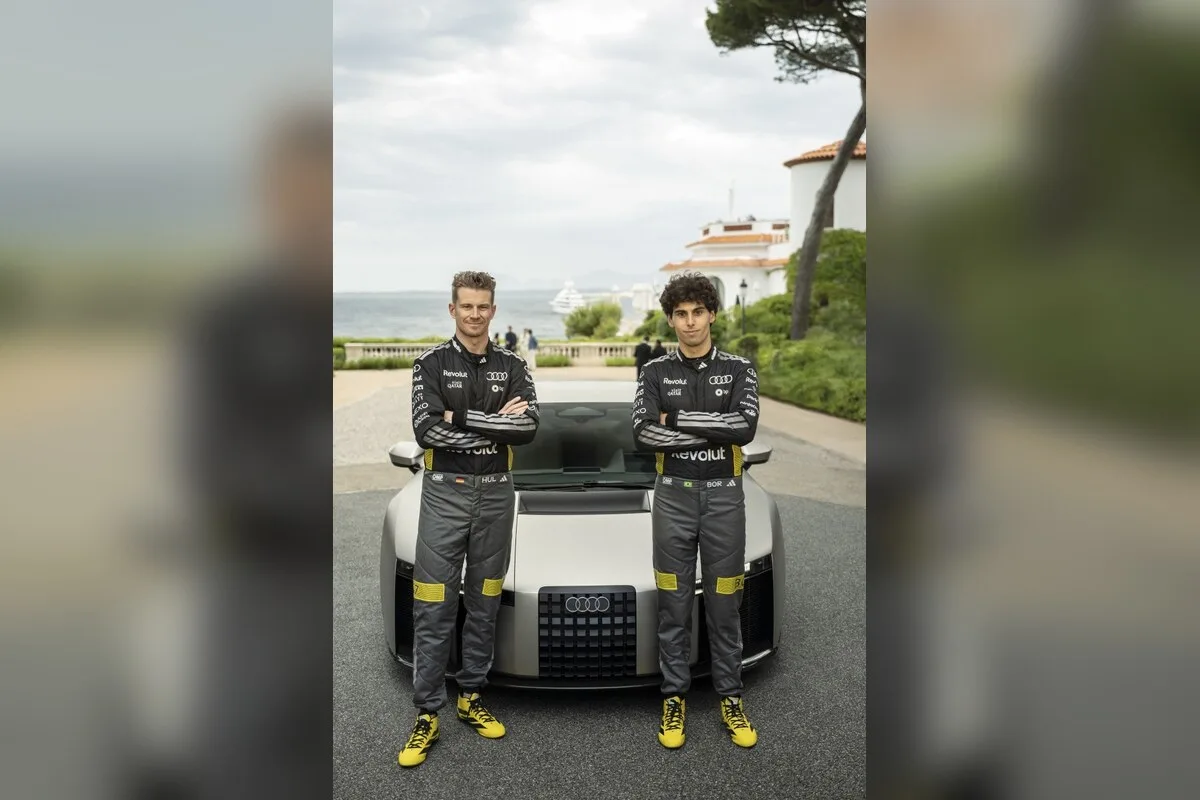 Nico Hulkenberg and Gabriel Bortoleto standing in race suits in front of the Audi Nuvolari