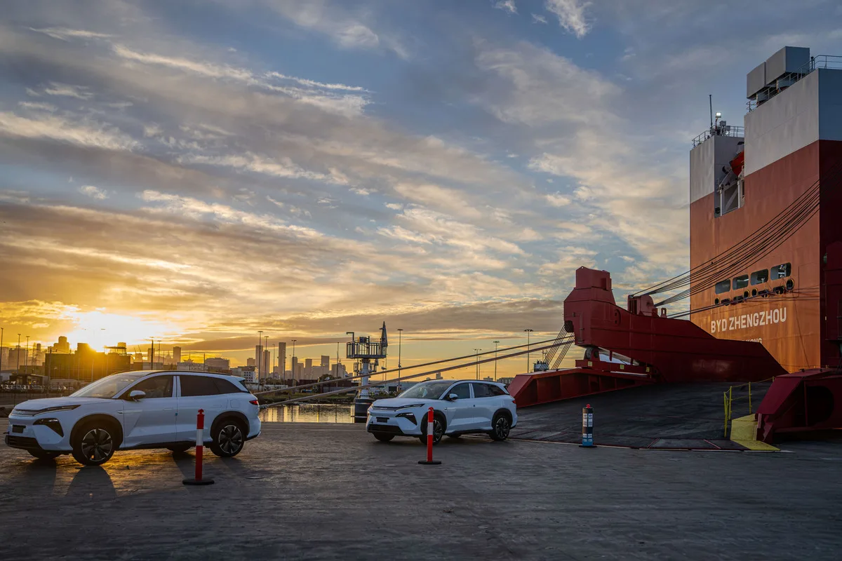 BYD vehicles parked beside the BYD Zhengzhou at the Port of Melbourne at sunset