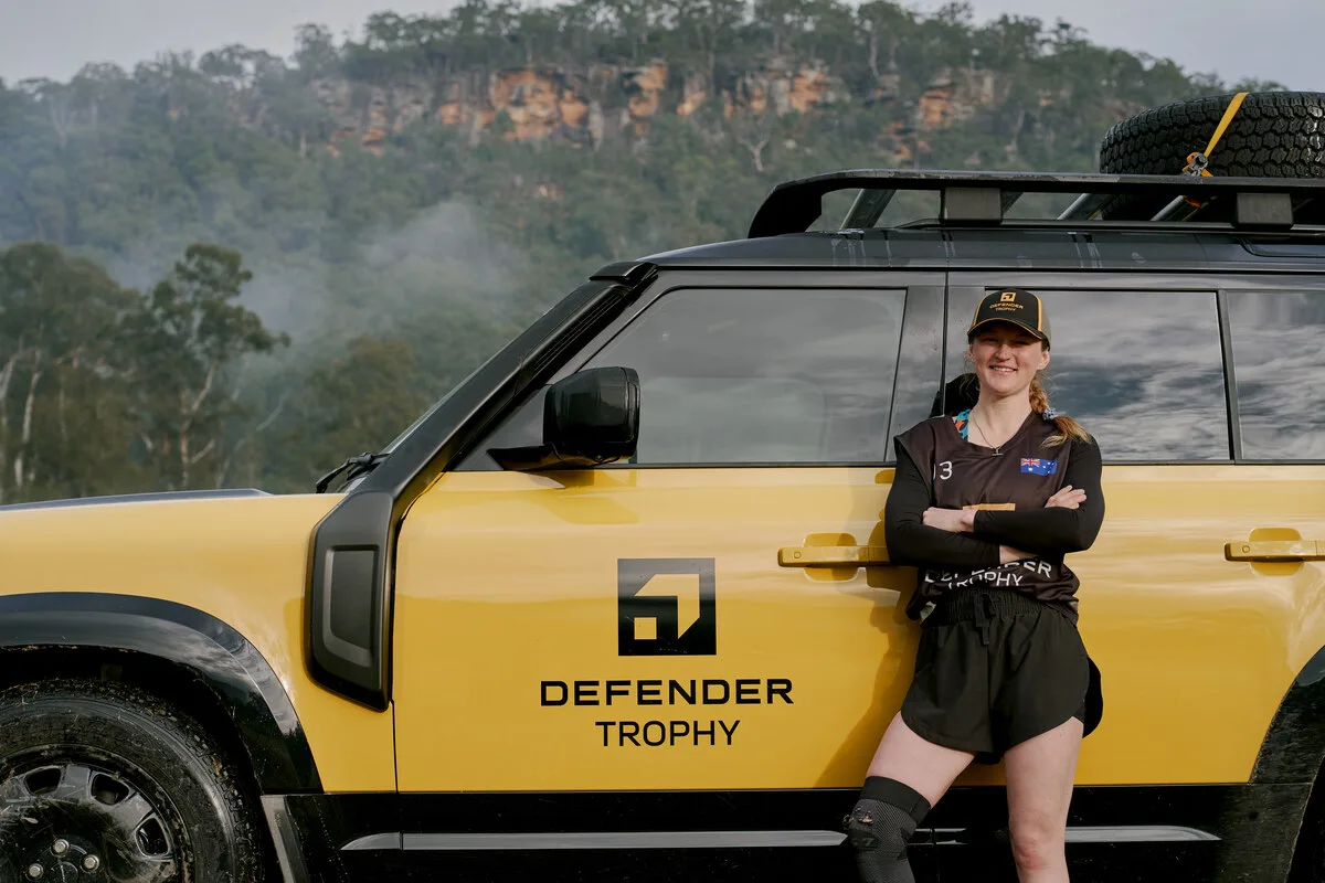 Australian Defender Trophy competitor standing beside a yellow Defender 110 Trophy vehicle