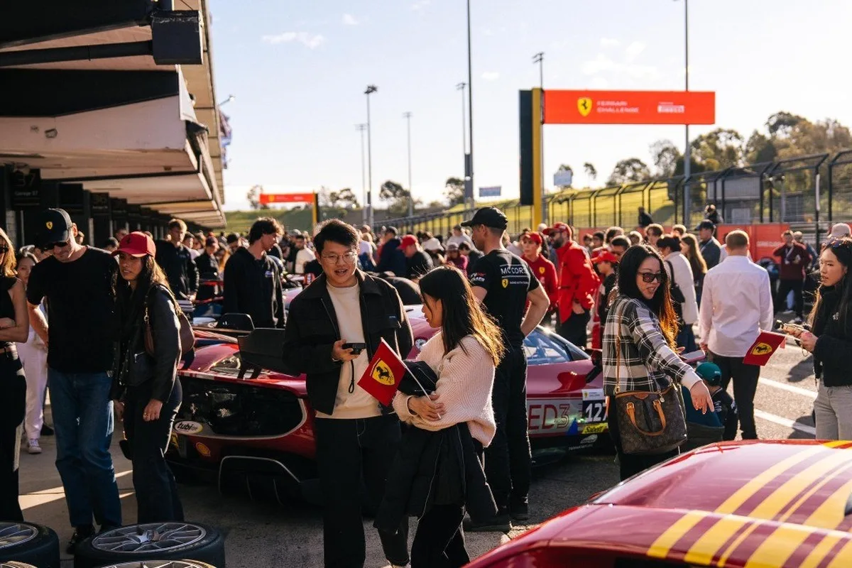 Spectators walking through the busy Ferrari Festival paddock at Queensland Raceway.