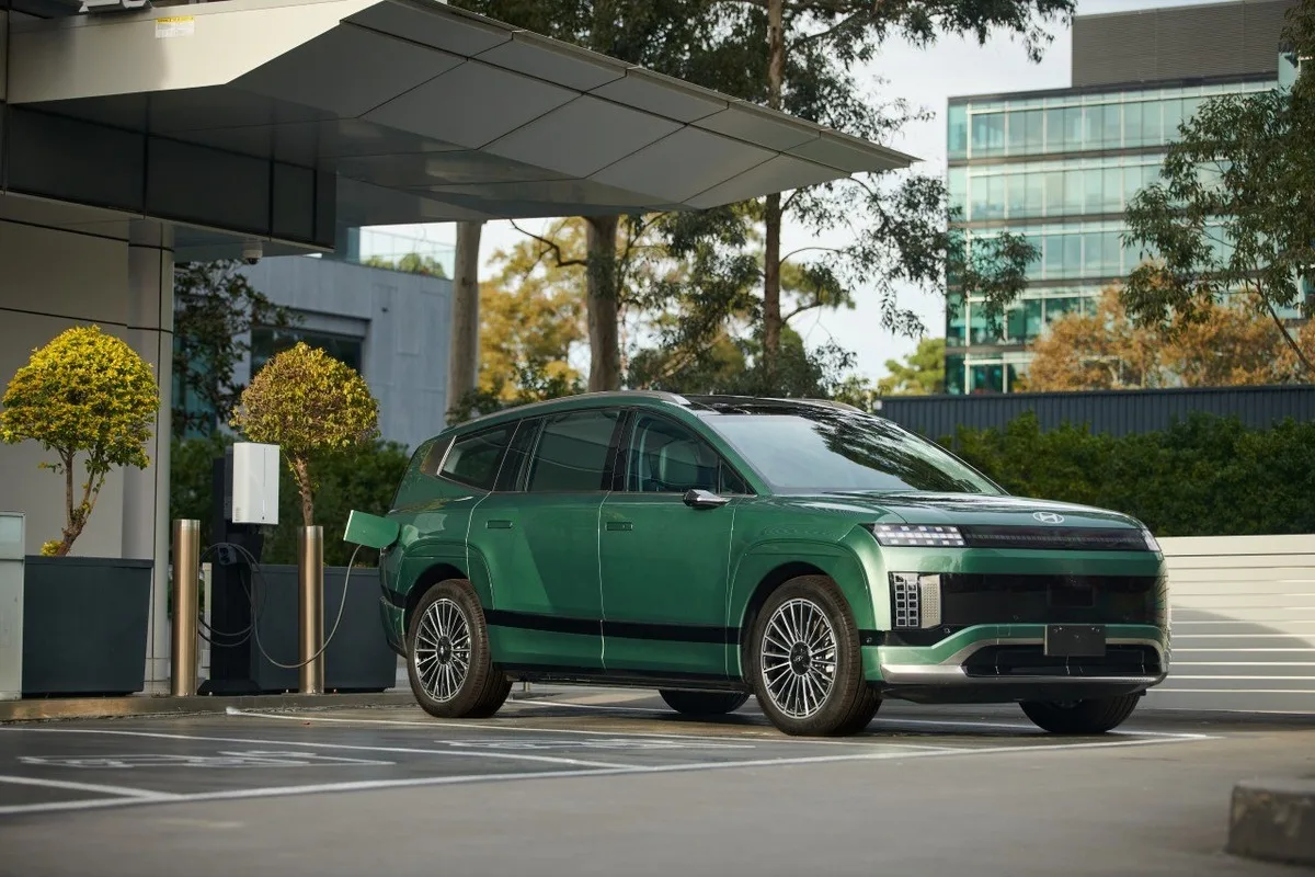 Green Hyundai IONIQ 9 connected to a bidirectional charger during Australia's first ISO 15118-20 Vehicle-to-Grid discharge