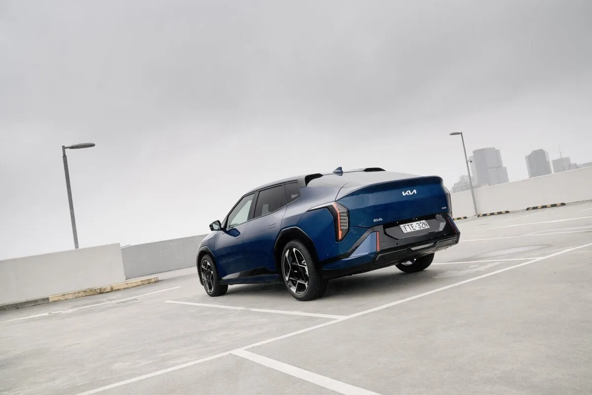Blue 2026 Kia EV4 Earth Long Range rear three-quarter view parked on a rooftop car park