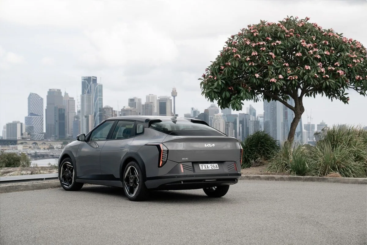 2026 Kia EV4 Earth Long Range rear three-quarter view parked above the Sydney city skyline