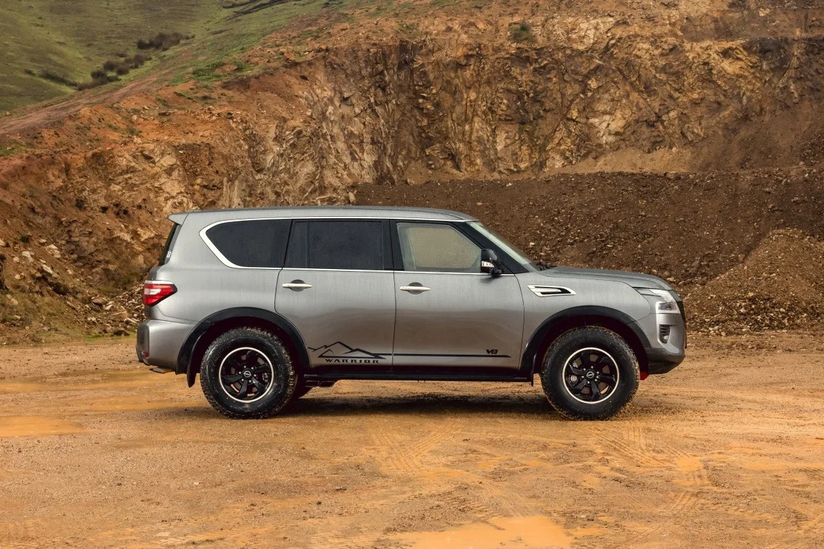 Grey Nissan Patrol Warrior side profile showing Warrior decals, off-road tyres, and raised stance.