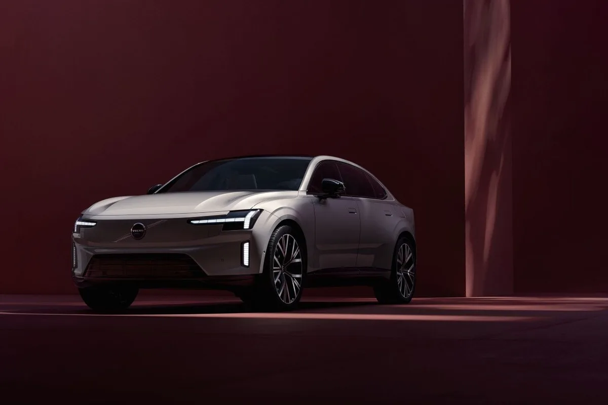 Volvo ES90 shown from the front three-quarter angle in a red studio setting