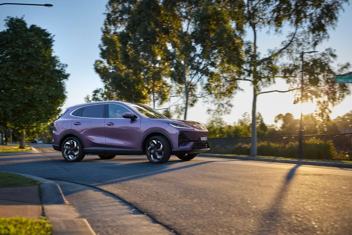 Purple Lepas L6 EV driving on an urban road at sunset