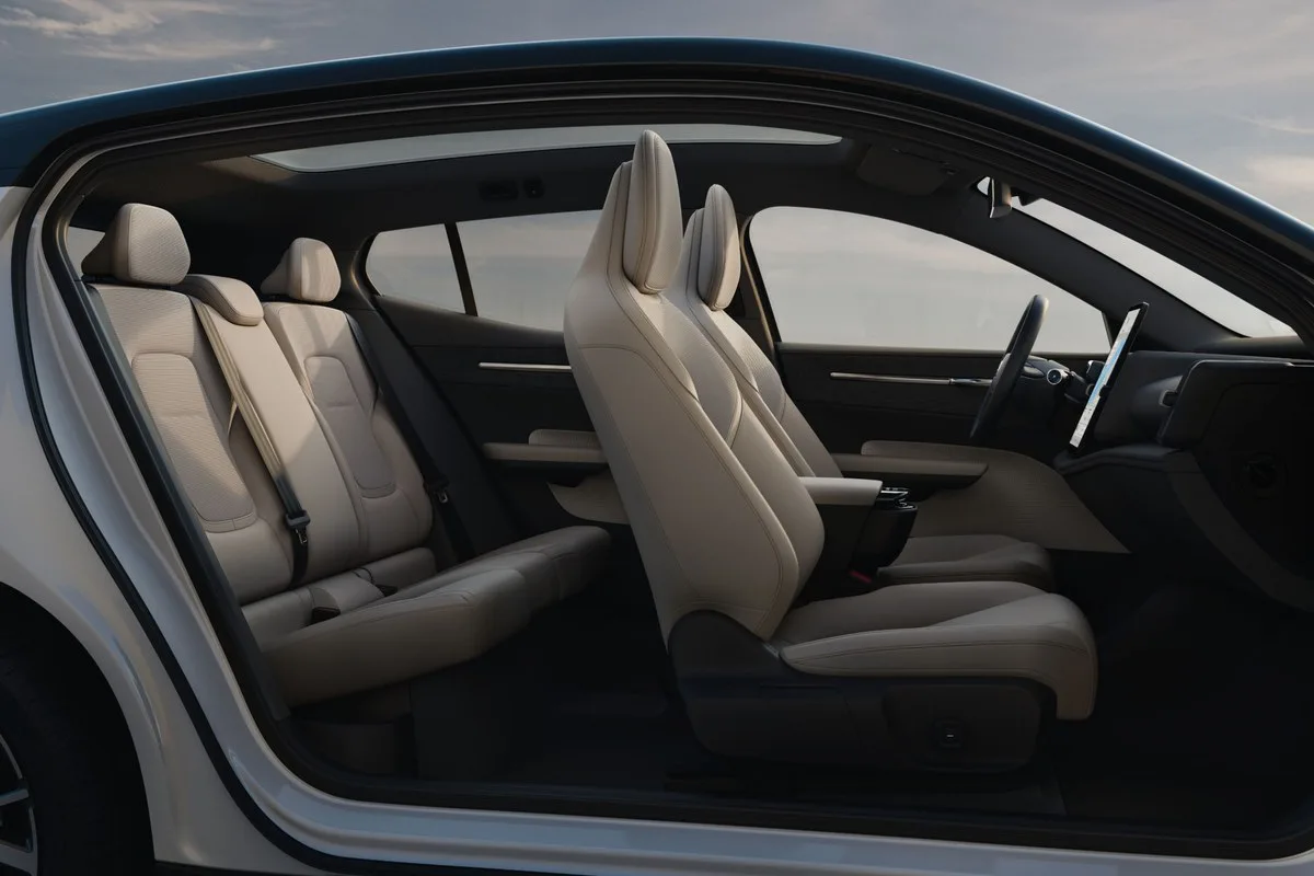 Cream interior of the Volvo EX30 seen through the open door, front and rear seats