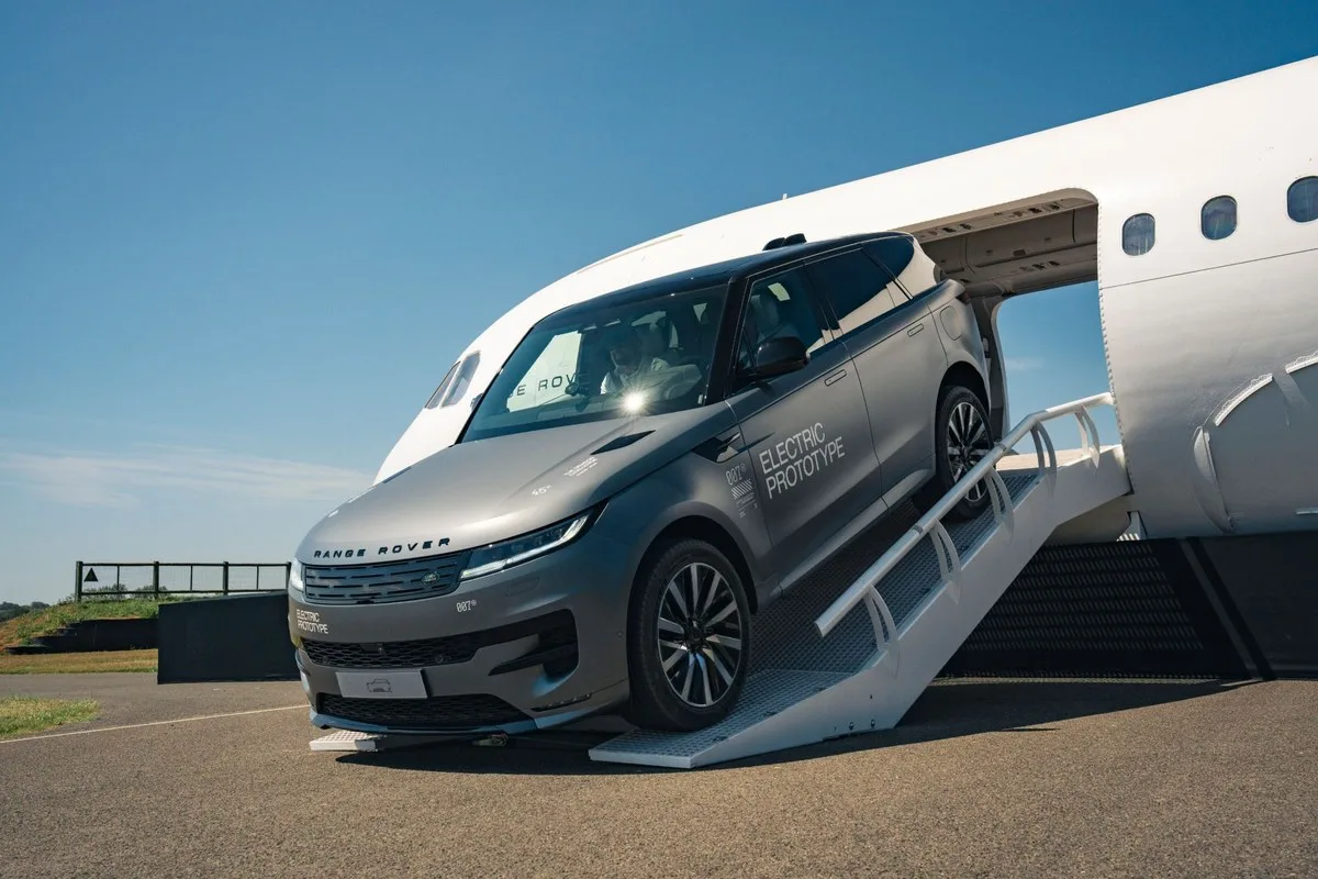 Grey Range Rover Sport Electric Prototype descending the aeroplane ramp