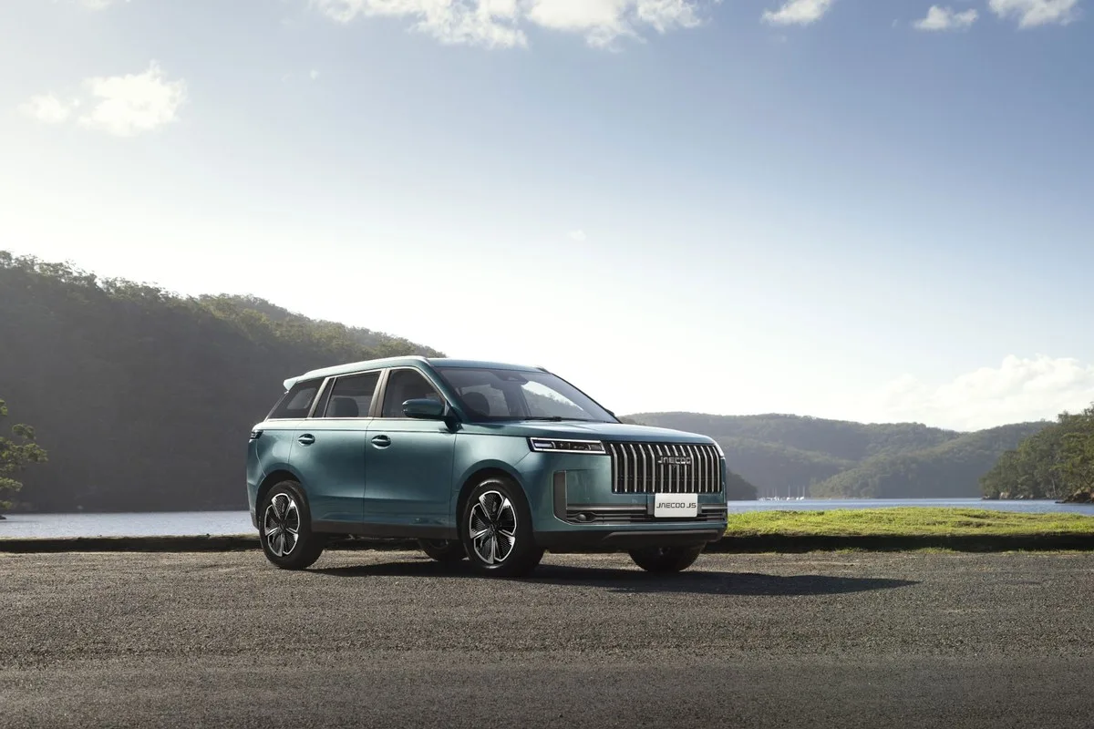 Teal Jaecoo J5 Hybrid SUV front three-quarter parked by a lake