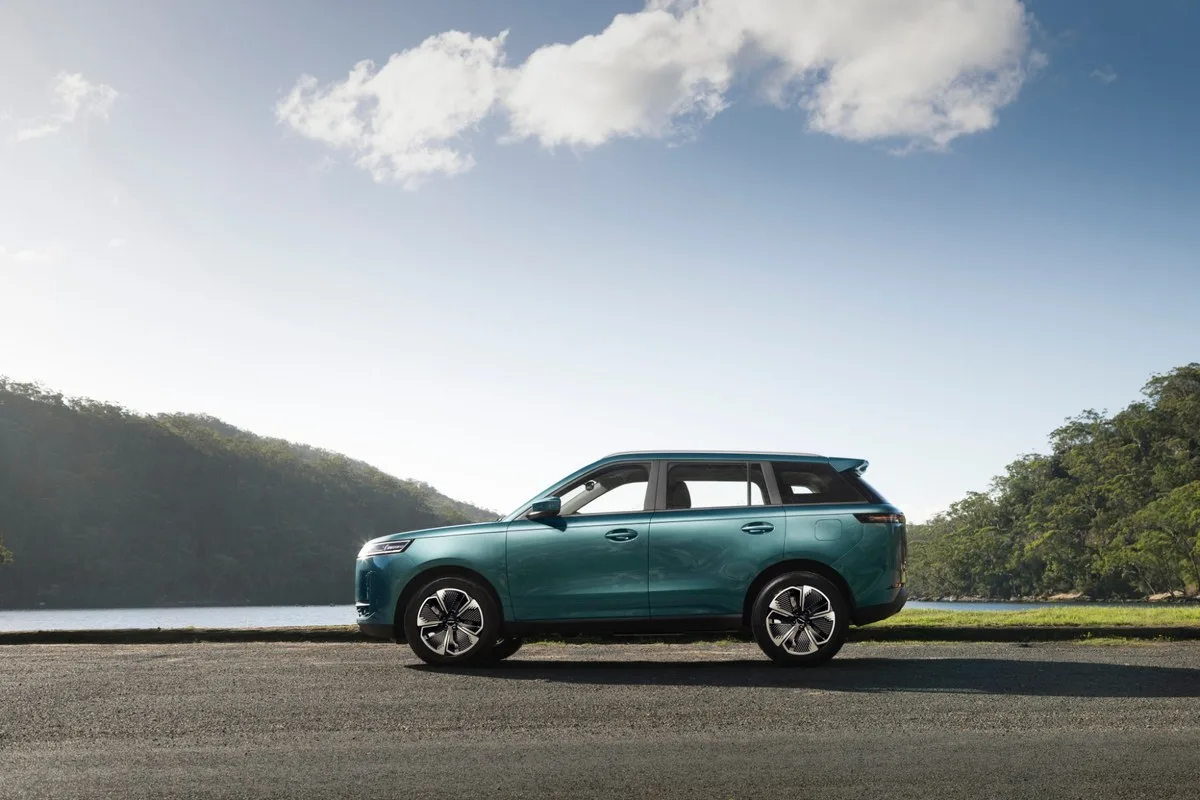 Teal Jaecoo J5 Hybrid SUV side profile by a lake