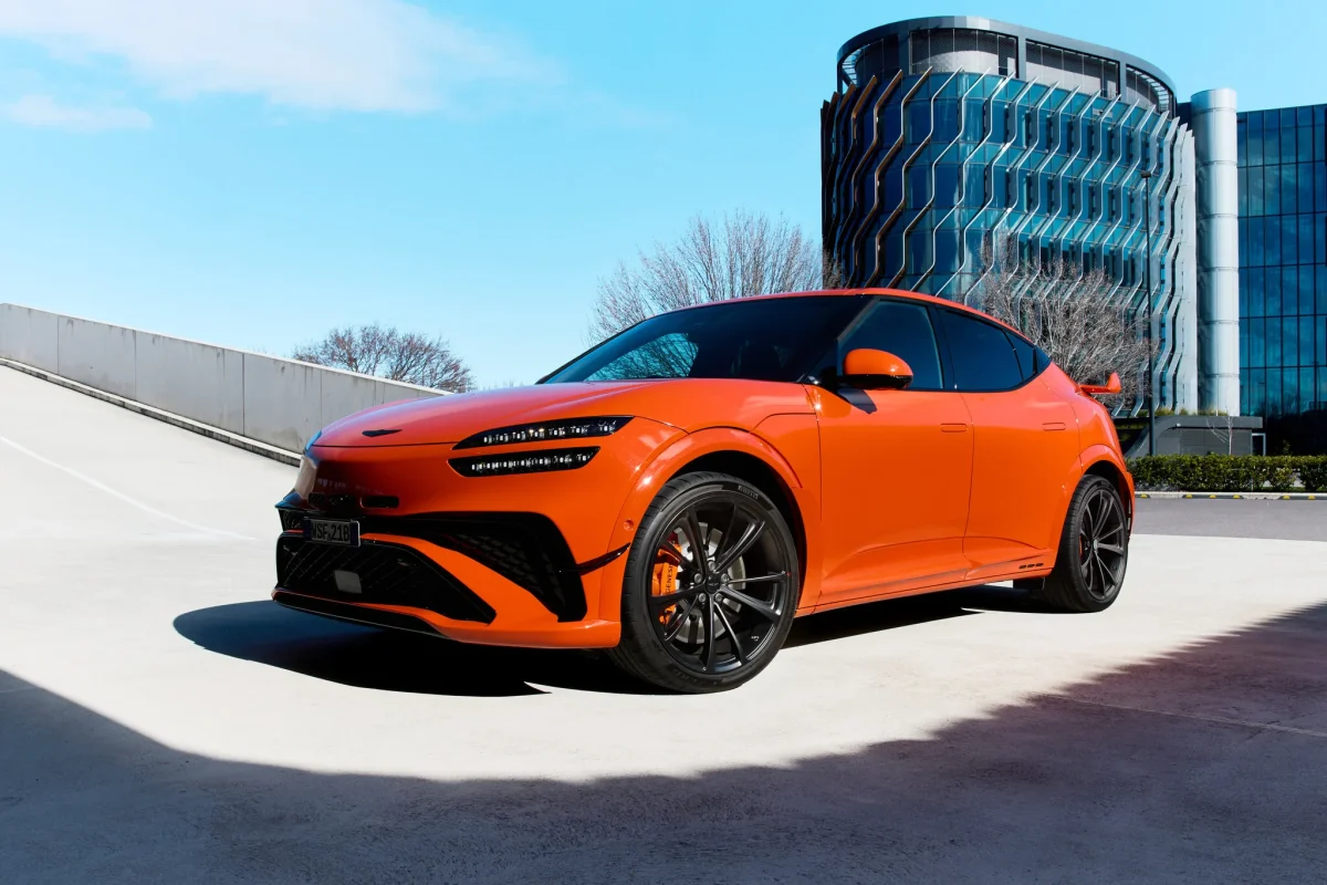 Magma Orange Genesis GV60 Magma front three-quarter view outside a building