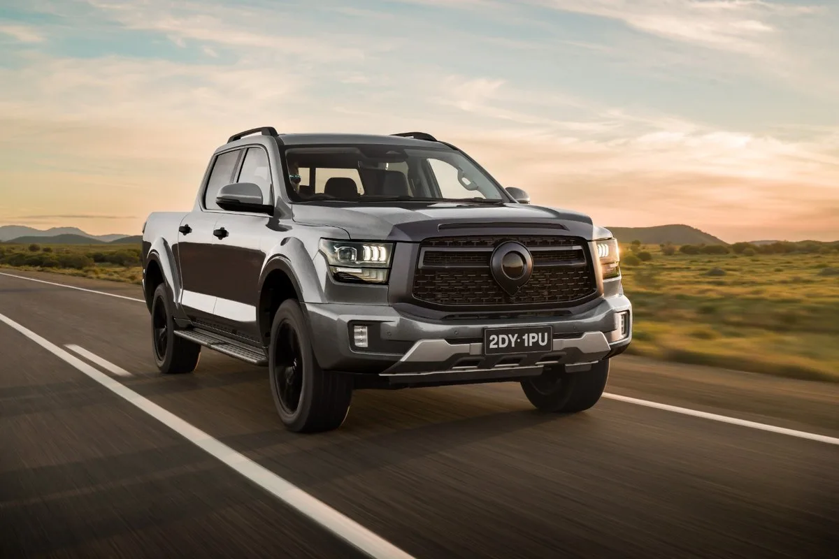 Grey GWM Cannon Alpha dual-cab ute driving on a country highway at dusk