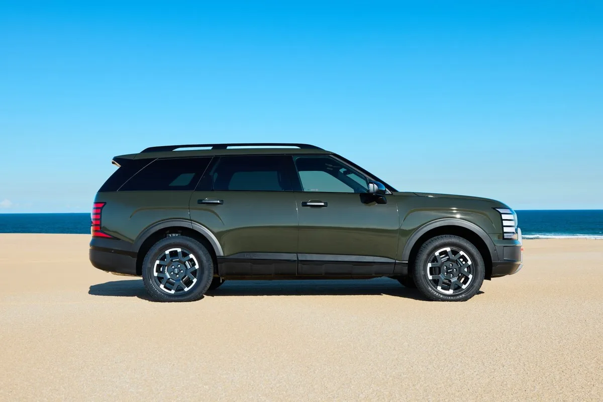 Hyundai Palisade XRT Pro in dark green, side profile on a beach