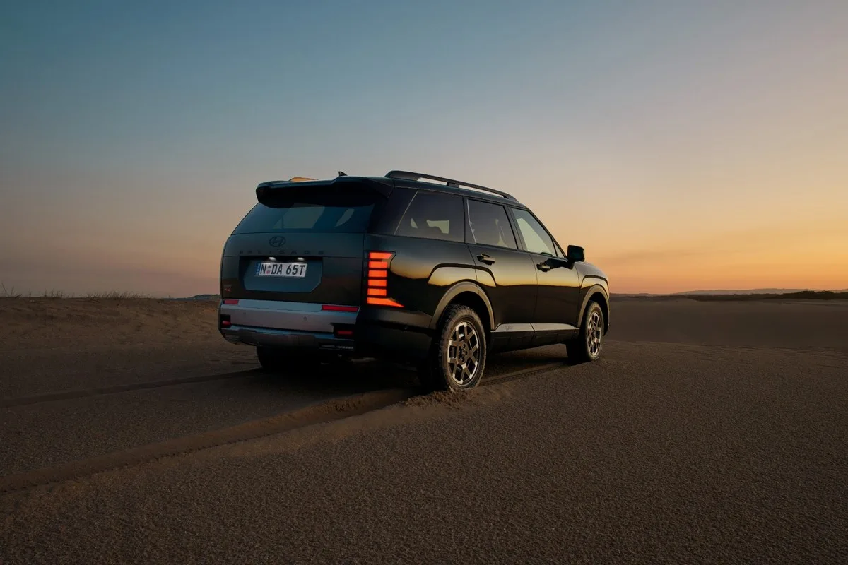 Hyundai Palisade XRT Pro in black, rear three-quarter view on sand