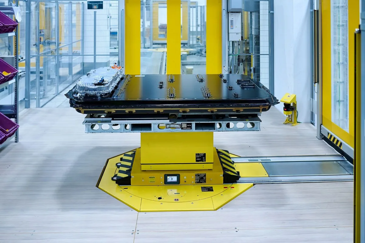 BMW Gen6 high-voltage battery pack on a yellow assembly platform, side view