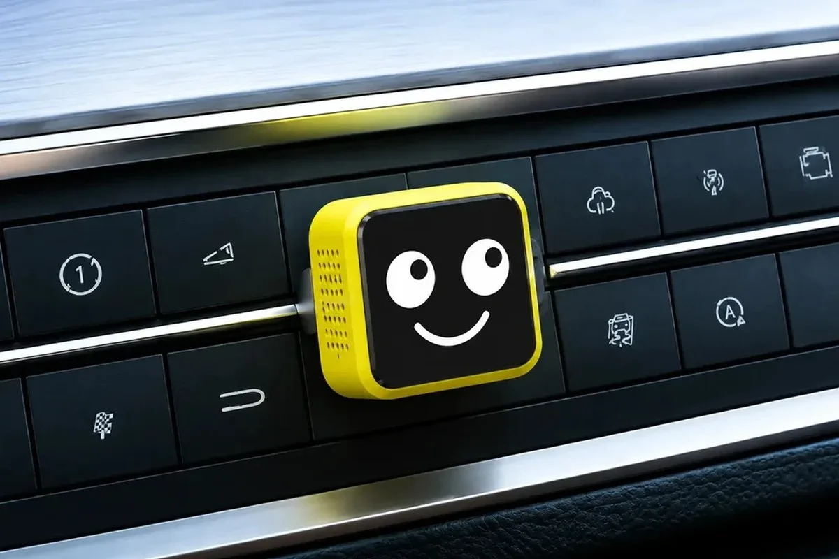 Yellow Lamtto RC38 wireless CarPlay adaptor with a smiley face plugged into a dash