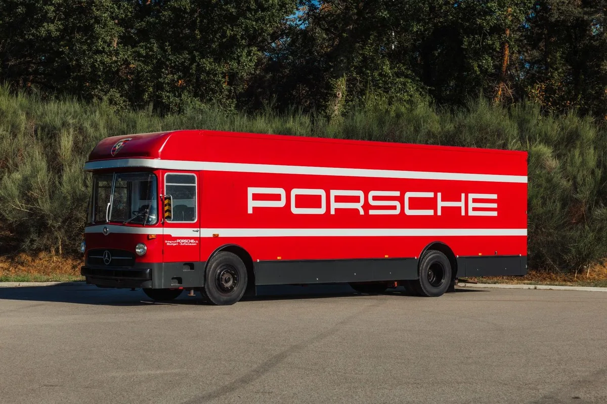 Red Mercedes-Benz O 317 transporter with white Porsche lettering