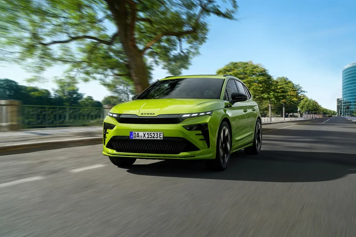 Green Skoda Enyaq RS electric SUV driving on a road