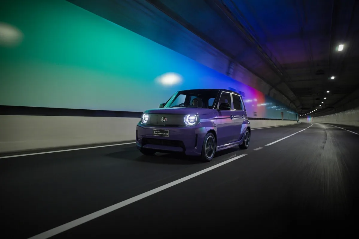 Honda Super-ONE driving through a lit road tunnel with headlights on