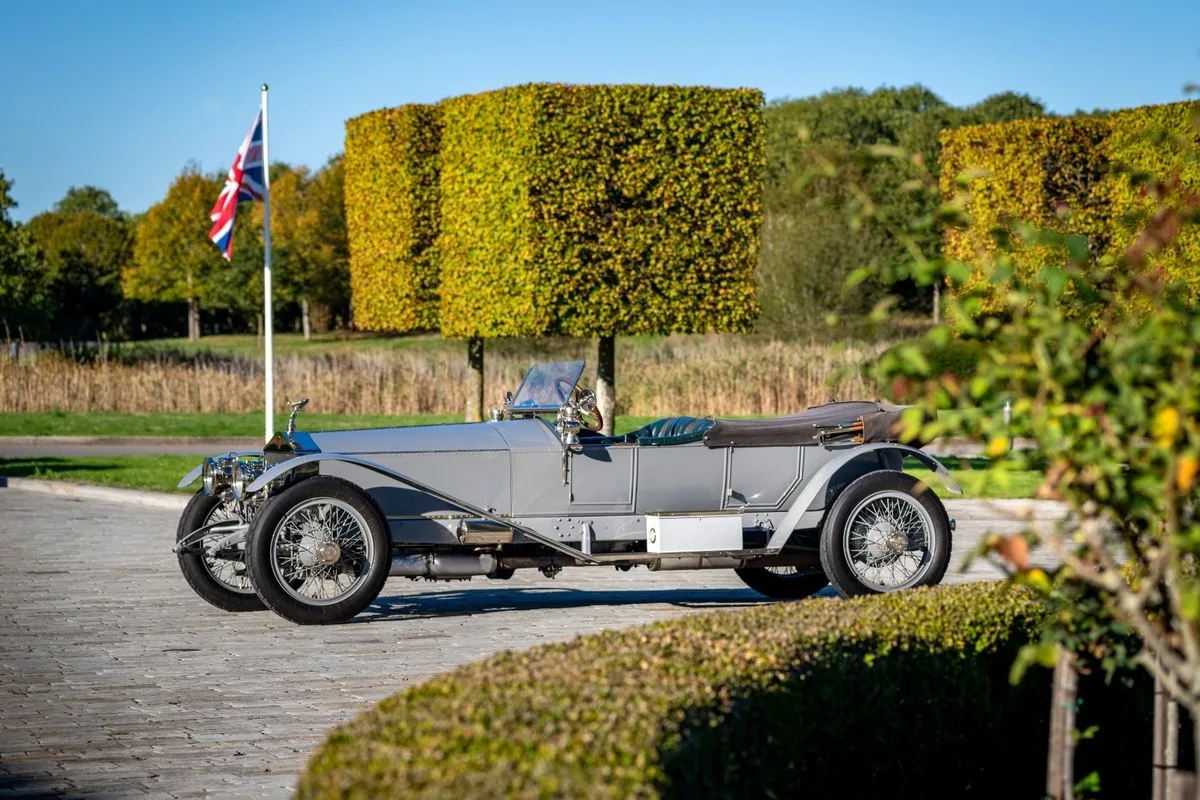 Silver Rolls-Royce Silver Ghost open tourer side view with topiary behind