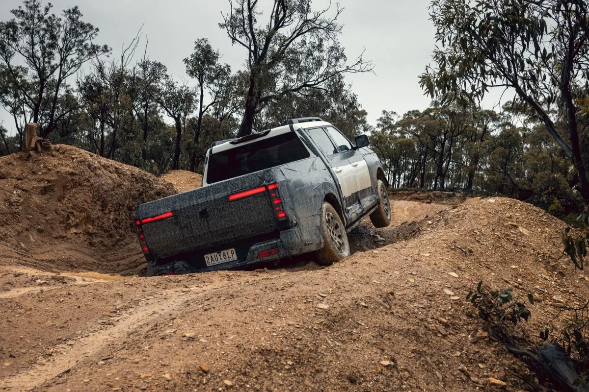 Nissan Navara Pro PHEV prototype climbing out of a deep dirt rut with one wheel lifted